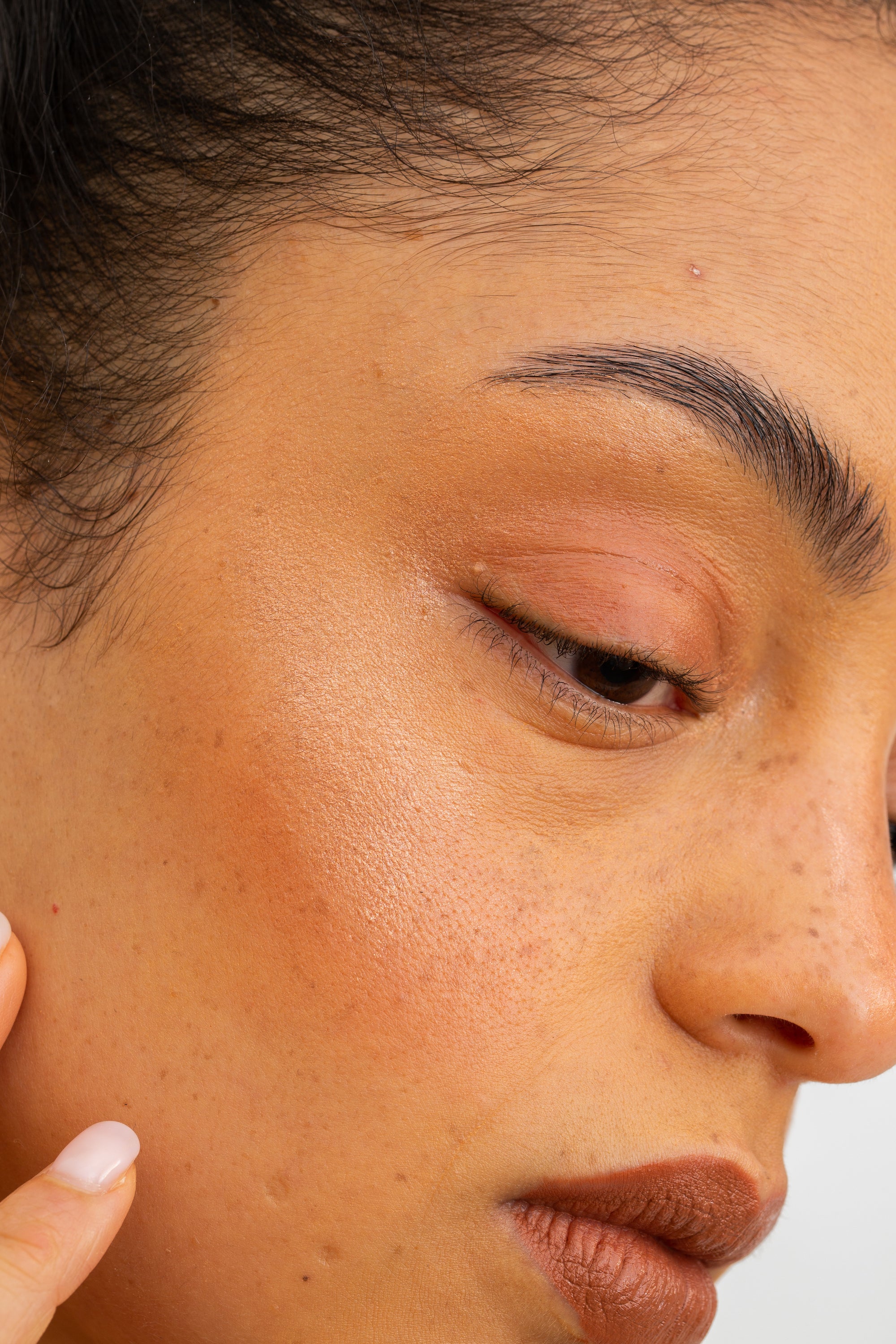 closeup image of skin dew in rose on cheekbone of light complexion