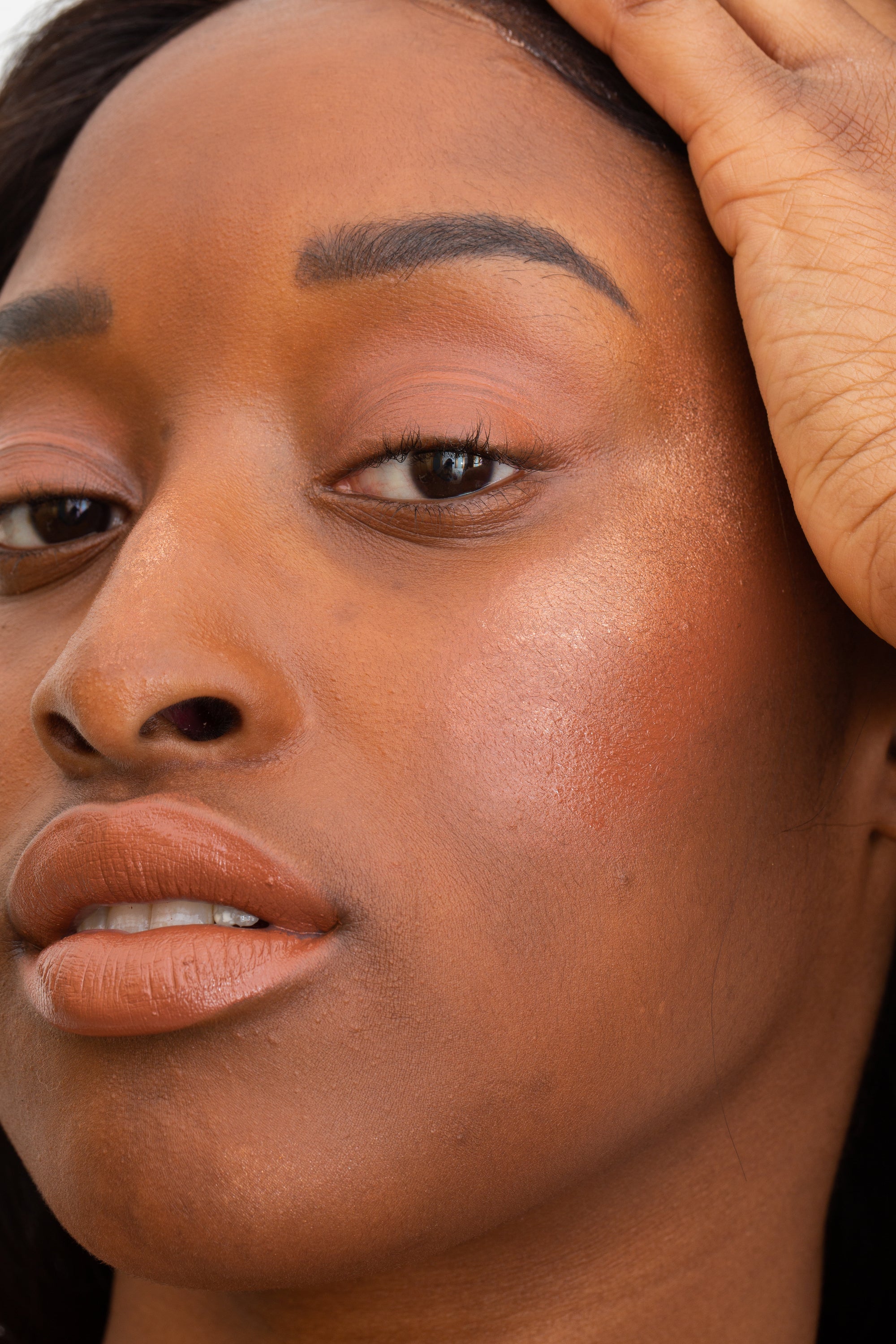 closeup image of deep complexion model wearing bubbly on the cheekbones